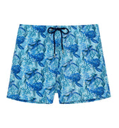 Blue swim shorts with turtle pattern on a white background